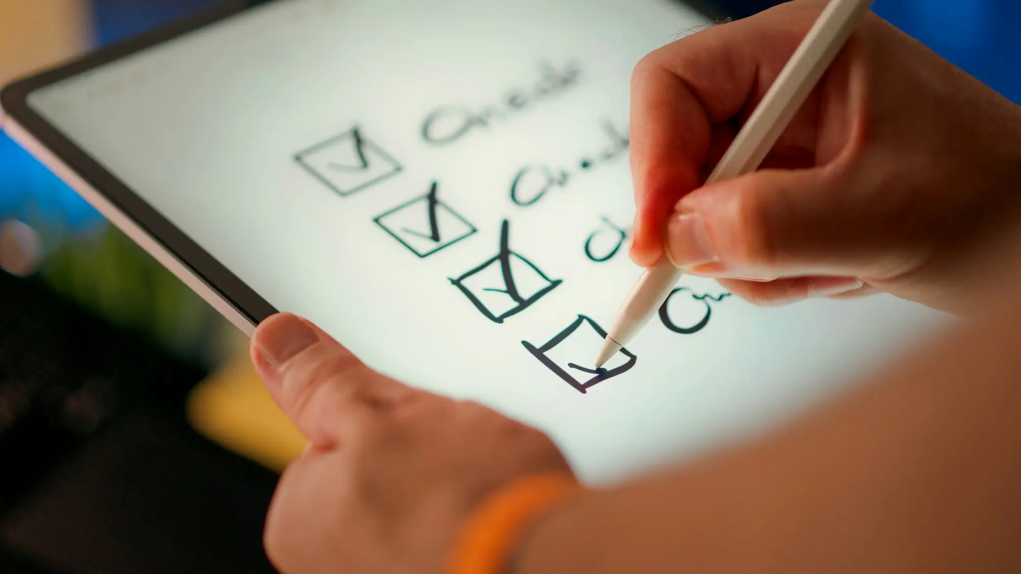 A hand ticking boxes on a checklist displayed on a tablet screen