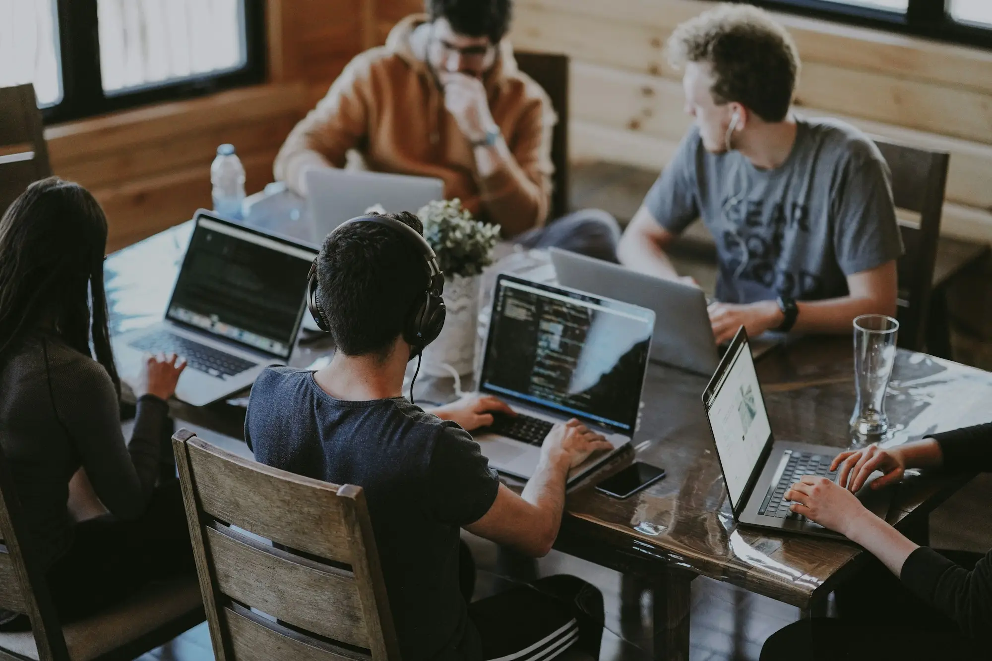 A team working together around a long table, each person on a laptop